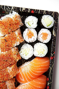 近摄的寿司食物在托盘上反对白色背景