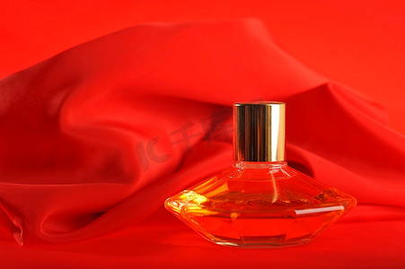 特写商品摄影照片_一瓶香水，隔离在红色特写上