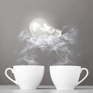 创意诞生灯泡躺在热气腾腾的咖啡杯上