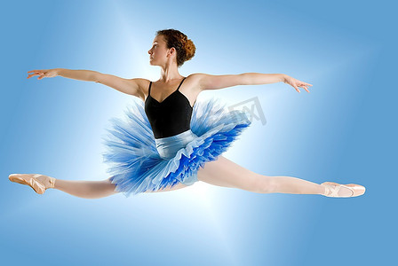 芭蕾舞裙摄影照片_穿着蓝色芭蕾舞裙的舞者在闪亮的蓝色背景上跳着巨型猪