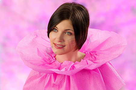 夏季粉色圆领短袖摄影照片_年轻可爱的黑发女郎穿着原创的粉色纸领连衣裙，看起来很甜蜜