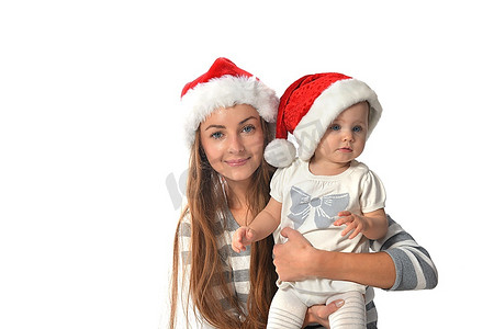 快乐的女婴和妇女在圣诞老人帽子。