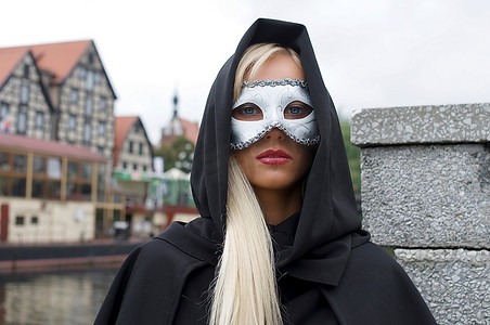 外面的画像漂亮的金发隐藏在一个白色的面具和兜帽后面面具面罩