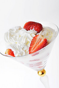 新鲜切碎的草莓配上玻璃器皿中的鲜奶油