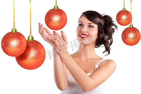 圣诞舞会摄影照片_漂亮的黑发与发型和白色连衣裙微笑和摆在圣诞舞会之间