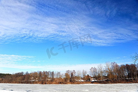 清明上河图白摄影照片_白雪覆盖的河岸上的树木和灌木丛。冬季景观