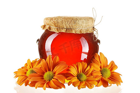 罐子里的蜂蜜和花朵隔着白色