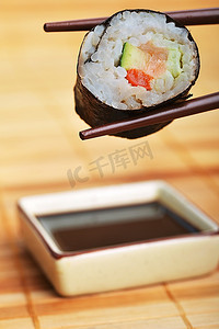 筷子间的寿司准备蘸酱汁