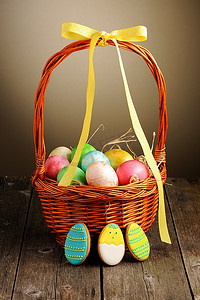 篮子里的饼干摄影照片_木桌上篮子里的彩色复活节彩蛋