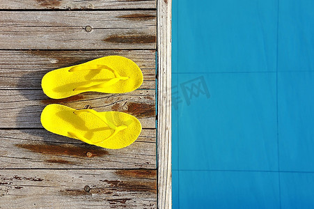 屈原鞋子摄影照片_游泳池边的黄色凉鞋