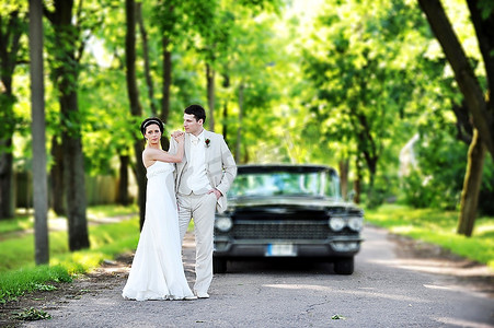 幸福的新人摄影照片_婚礼结束后，新人在车旁