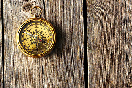 航海复古背景摄影照片_木质背景的古董黄铜指南针