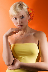 美插摄影照片_金发碧眼的可爱女孩，头发上插着橘黄色的鲜花