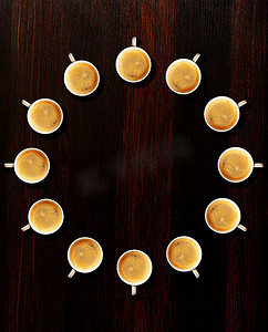团队合作由桌子上的新鲜浓缩咖啡杯制成的圆圈，从上面看