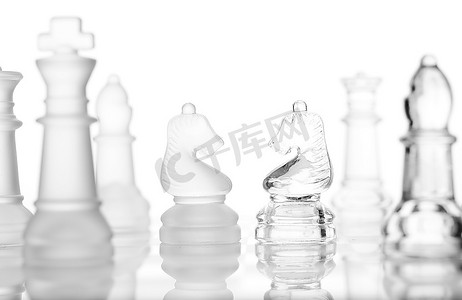 象棋游戏摄影照片_白色上孤立的透明玻璃象棋