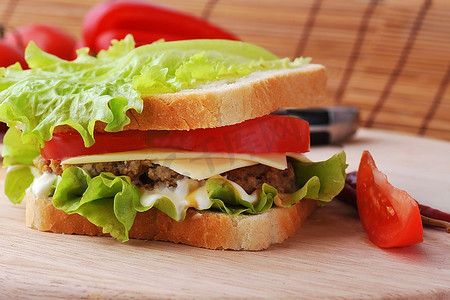 夹着肉排和蔬菜的三明治放在盘子里