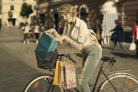 性感的金发女购物者用复古颜色的自行车赢得旧时尚大赛