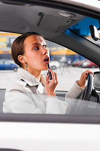 口红女士摄影照片_一位优雅的女士在车里边跑边化妆