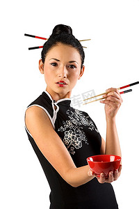 红色的筷子摄影照片_美丽的亚洲女孩在日本的着装和筷子显示一个红色的杯子