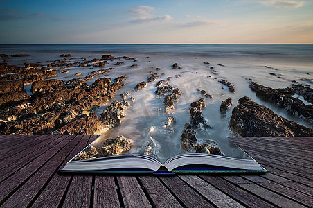 书创造性的概念页岩石海滩风景图象在日落与长曝光运动模糊海