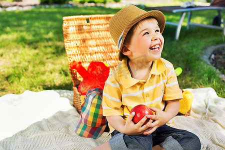 孩子眼睛摄影照片_微笑的孩子拿着多汁的苹果