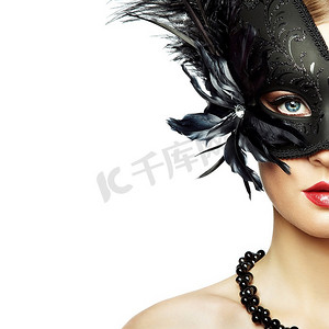 戴着黑色神秘威尼斯面具的美丽年轻女子。时尚写真