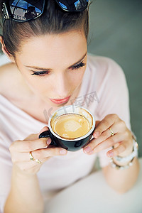大口摄影照片_迷人的黑发女子大口喝着咖啡