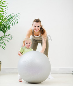 健身球摄影照片_母亲和婴儿玩健身球的肖像