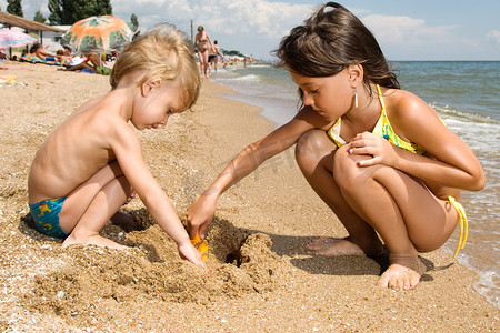 挖砂在海滩上的两个年轻孩子