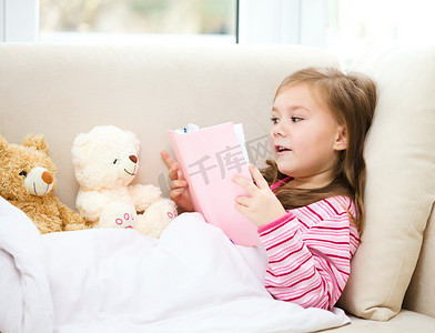 小女孩她的玩具熊读一本书