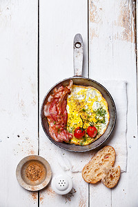 与煎的鸡蛋和培根平底锅上早餐