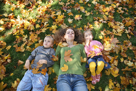 人像图标磨砂摄影照片_儿子和女儿的女人他们躺在草地上，2