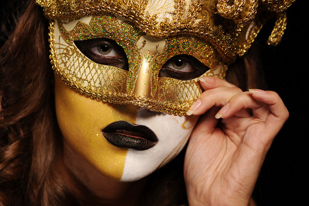 化妆舞会面具摄影照片_性感的女人在金色舞会面具