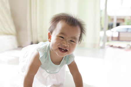 亚洲婴儿 10 个月岁爬在客厅里的脸