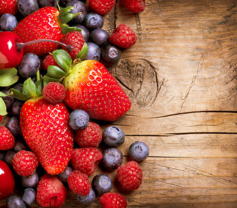 木制背景的莓果。在木有机草莓