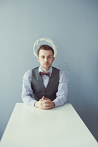 男士背心摄影照片_坐在餐桌背心的年轻商业男人
