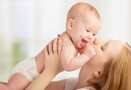 快乐年轻的妈妈亲吻宝宝