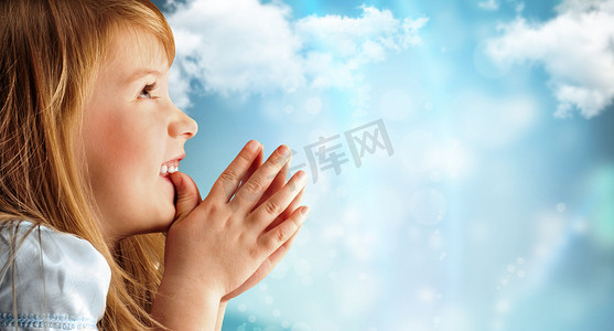 求子摄影照片_对天空的蓝色衣服的年轻微笑祈祷女孩的肖像