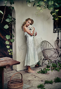 白色的裙子摄影照片_白色的裙子，抱着她的小狗的可爱女人