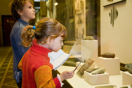 文化科技摄影照片_男孩和小女孩在游览在历史博物馆附近展邀请函