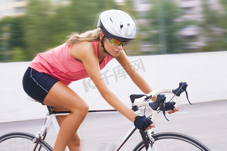 年轻美丽高加索专业骑自行车者在移动
