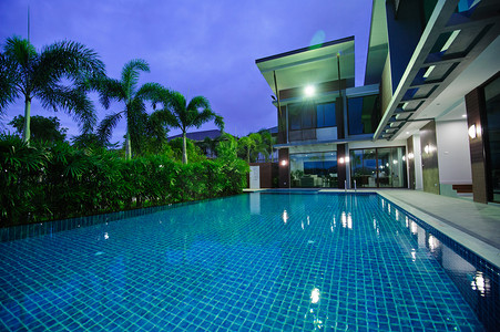 有钱的人摄影照片_现代的房子，有室外游泳池，在夜间 