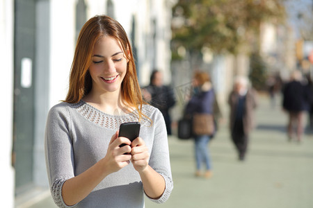 女人在街上浏览一部智能手机
