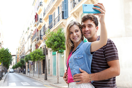 couple taking pictures and selfies using a smartphone
