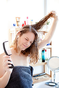 年轻的女孩照顾她的头发在浴室里
