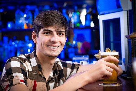 喝酒应酬摄影照片_一个年轻人在酒吧里的肖像