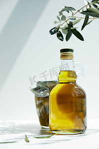 桌上放有绿色橄榄的芳香橄榄油、树枝和瓶子