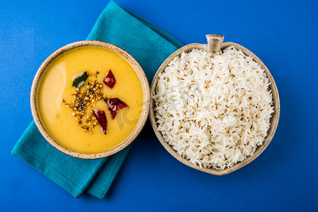 印度餐厅摄影照片_全黄扁豆，配米、大豆蔻、杰拉米、印度面、煮熟的米、煮好的Arhar或Toor dal（鸽子豆），装在陶瓷碗里，放在绿色垫子上