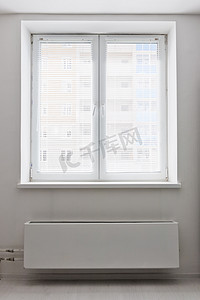 散热器摄影照片_白色塑料双门窗口在它之下的散热器. 