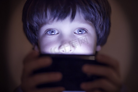儿童智能摄影照片_在智能手机上玩的小孩